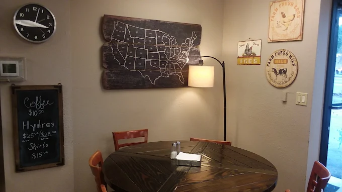 A cozy corner table at The Grind Coffee House with a lamp and vintage wall art